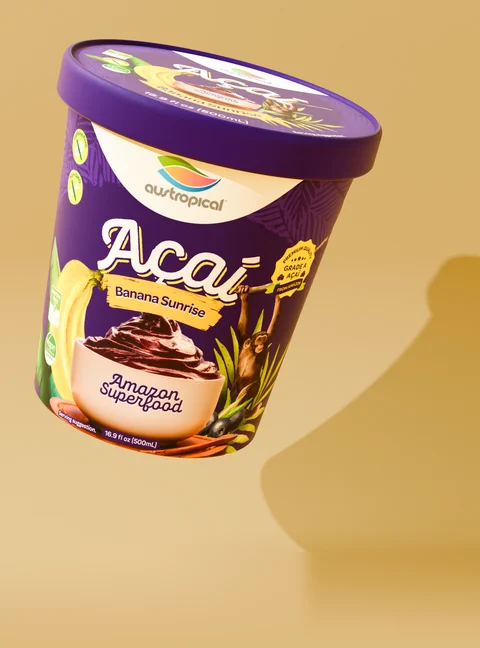 Austropical Açaí Banana Sunrise closed pint with its lid visible, on a colored background with a curved shadow