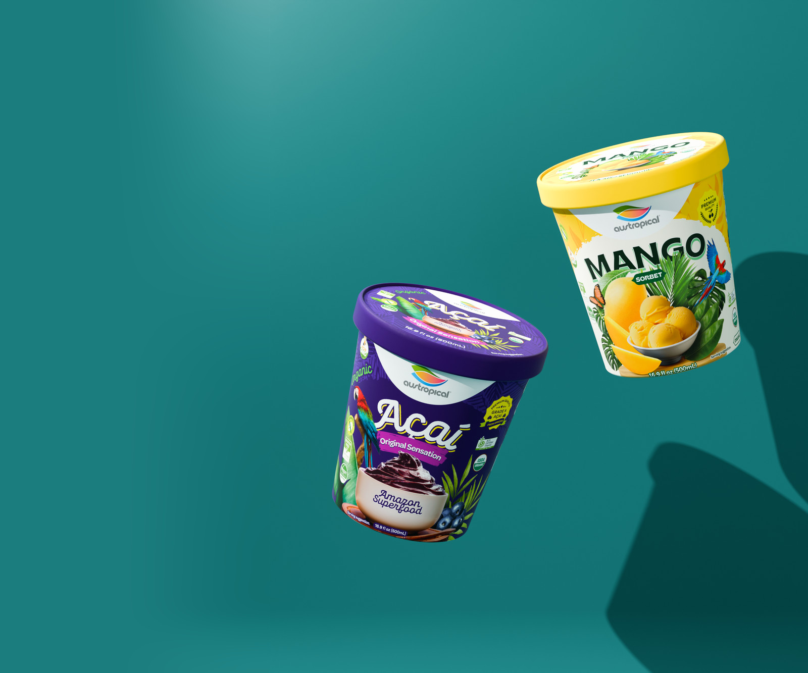 Austropical Organic Açaí Original Sensation and Organic Mango sorbet pints floating apart on a deep teal background, their shadows cast on the wall behind them.