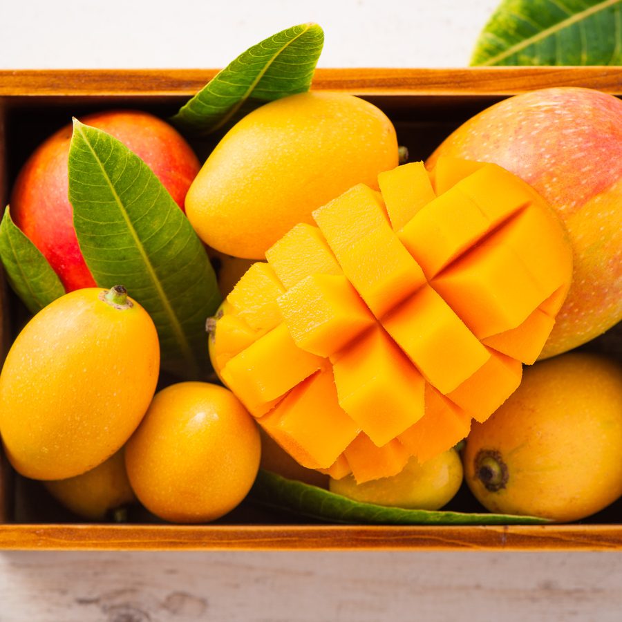 Ripe mangoes, one cut into cubes